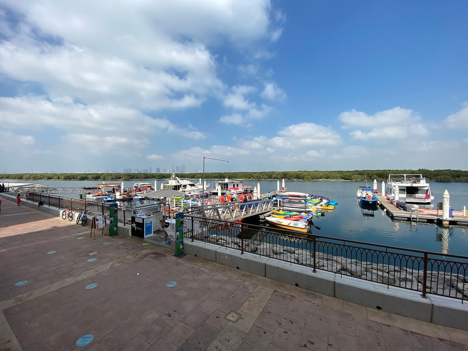 Kayak and boat docks at the Eastern Mangroves, with the mangrove treeline and the Abu Dhabi skyline behind