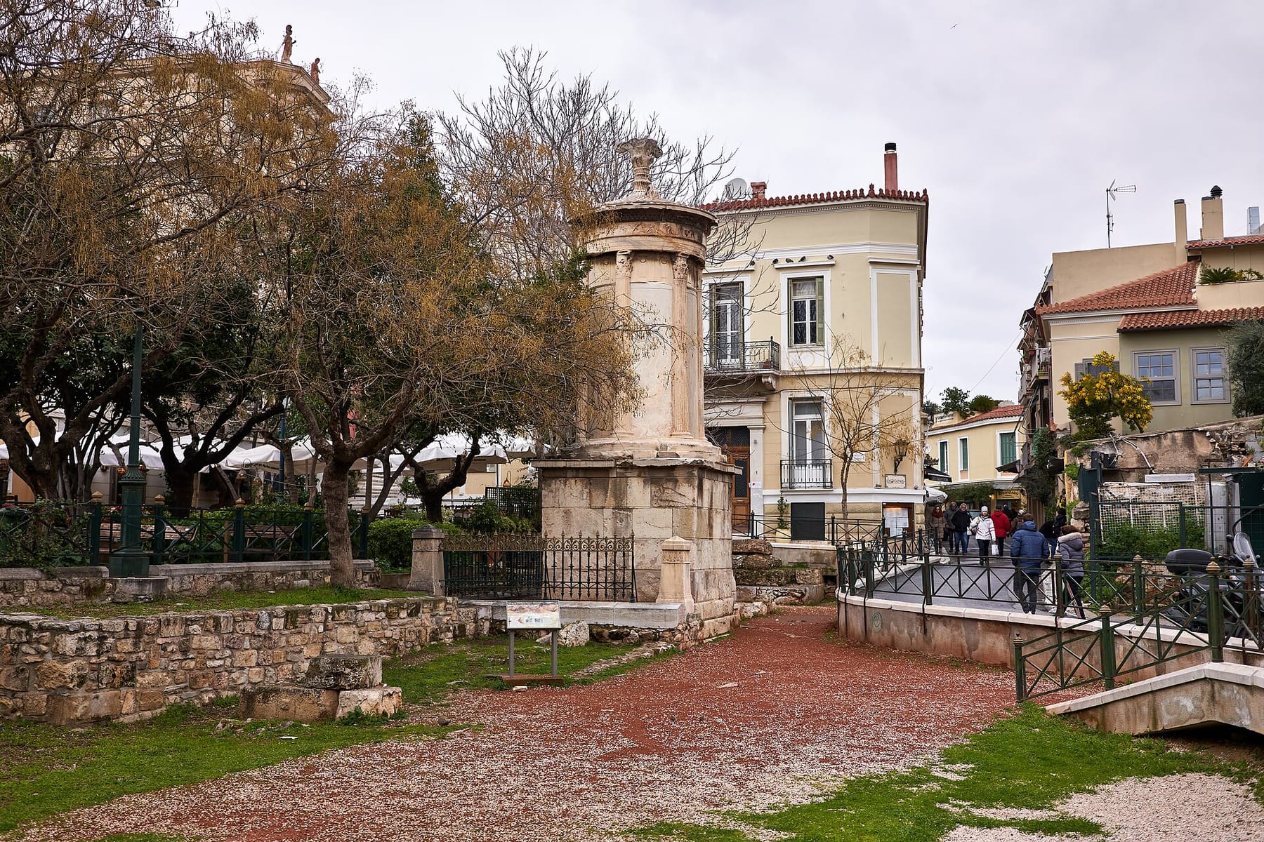 The Choragic Monument of Lysicrates in its small Plaka square, a round marble tower on a stone base with cafés and neoclassical houses behind