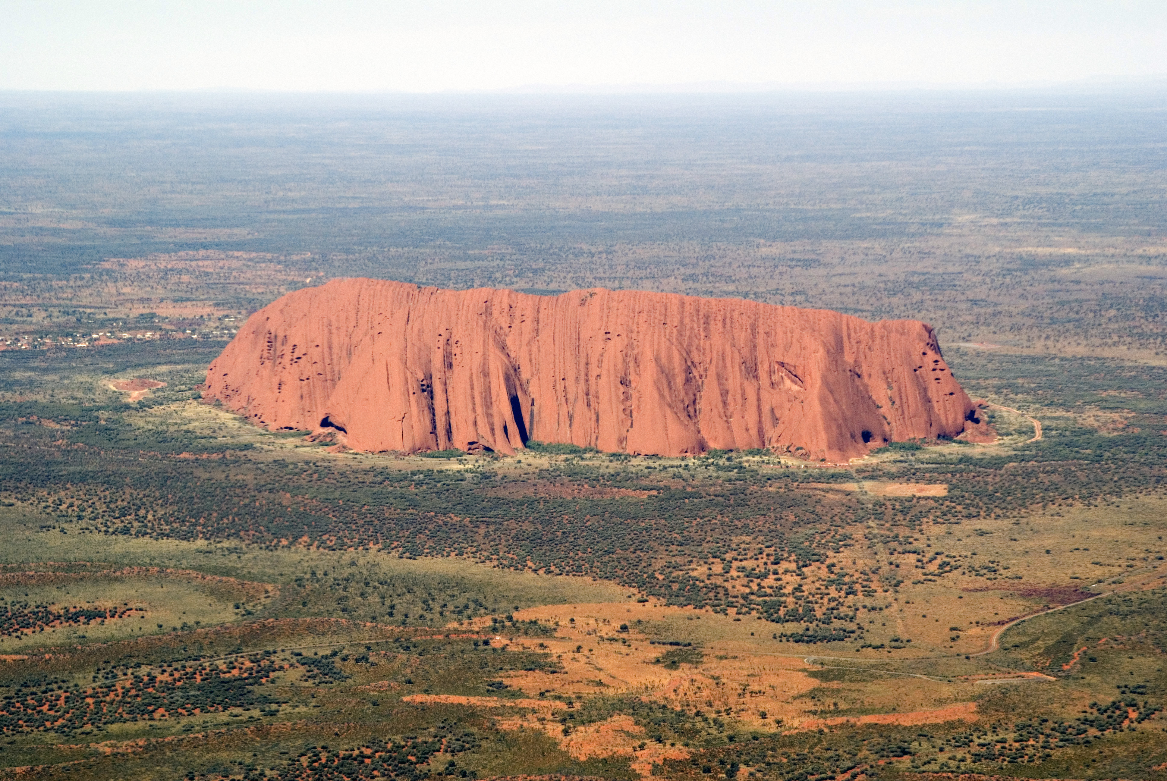 Aerial view of Uluru rising from the red Central Australian desert