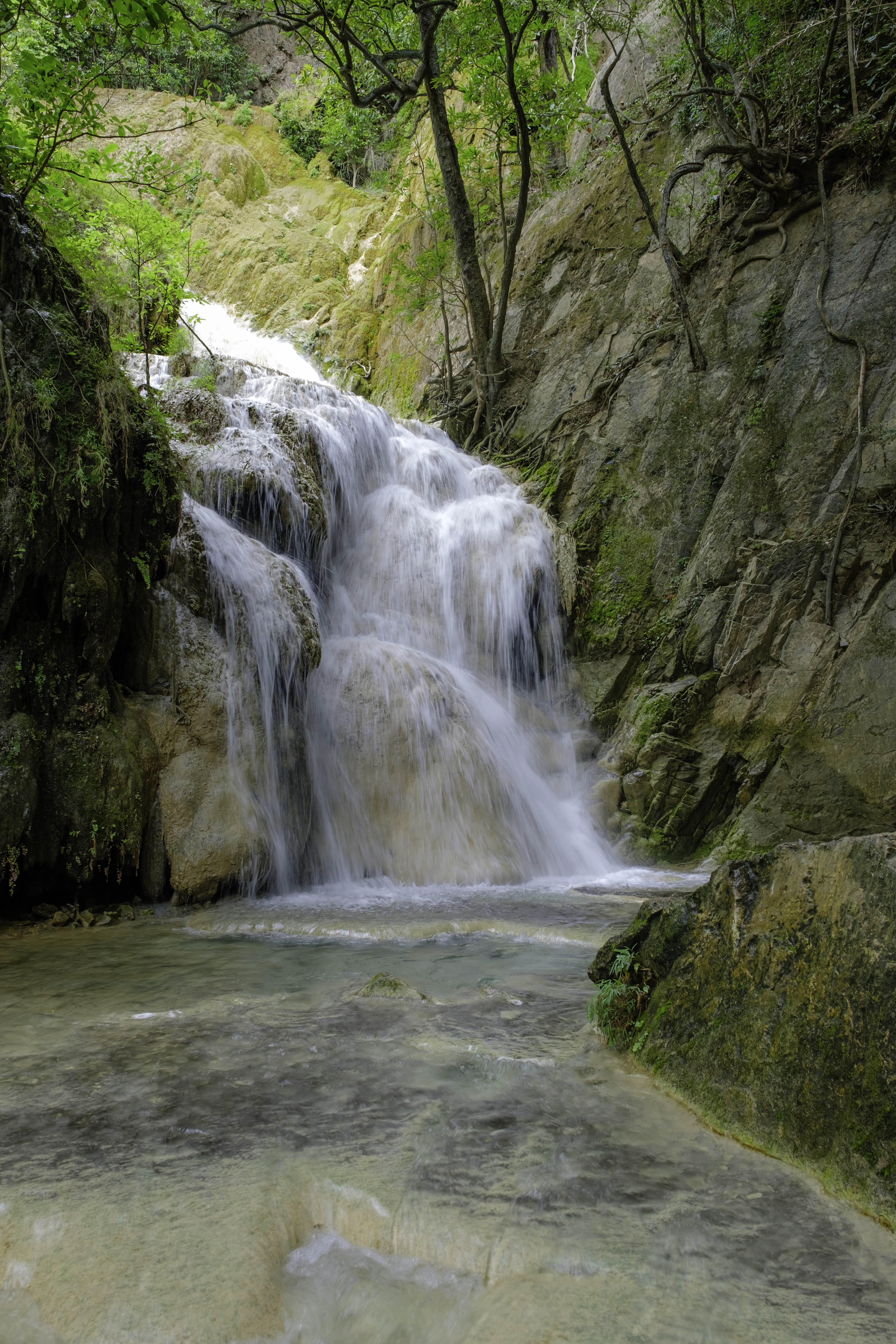 One of the seven limestone tiers of Erawan Falls cascading into a turquoise pool, Erawan National Park