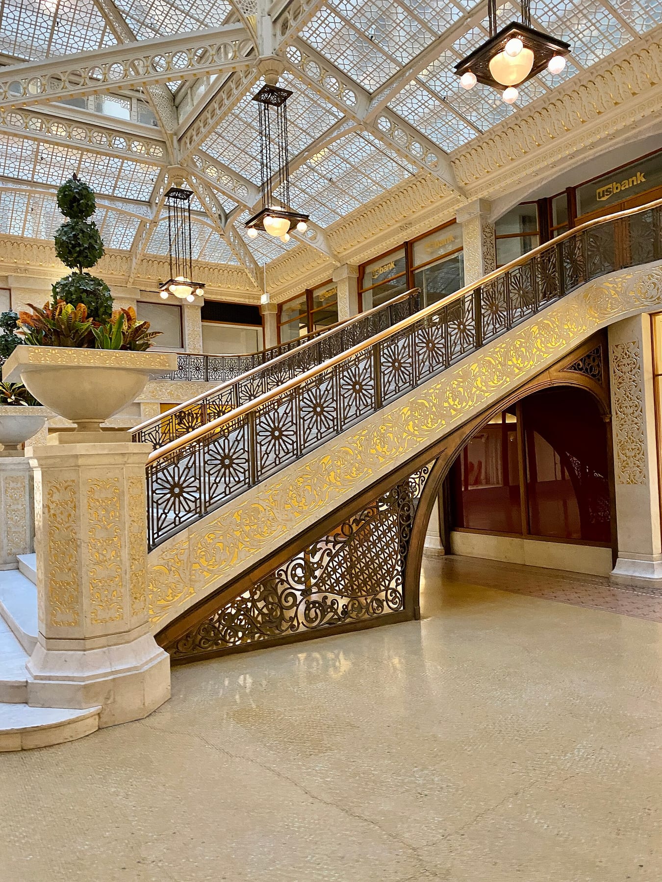 The gilded marble staircase and glass-roofed light court in the lobby of the Rookery Building in the Chicago Loop, the kind of interior the walking tour on this page enters