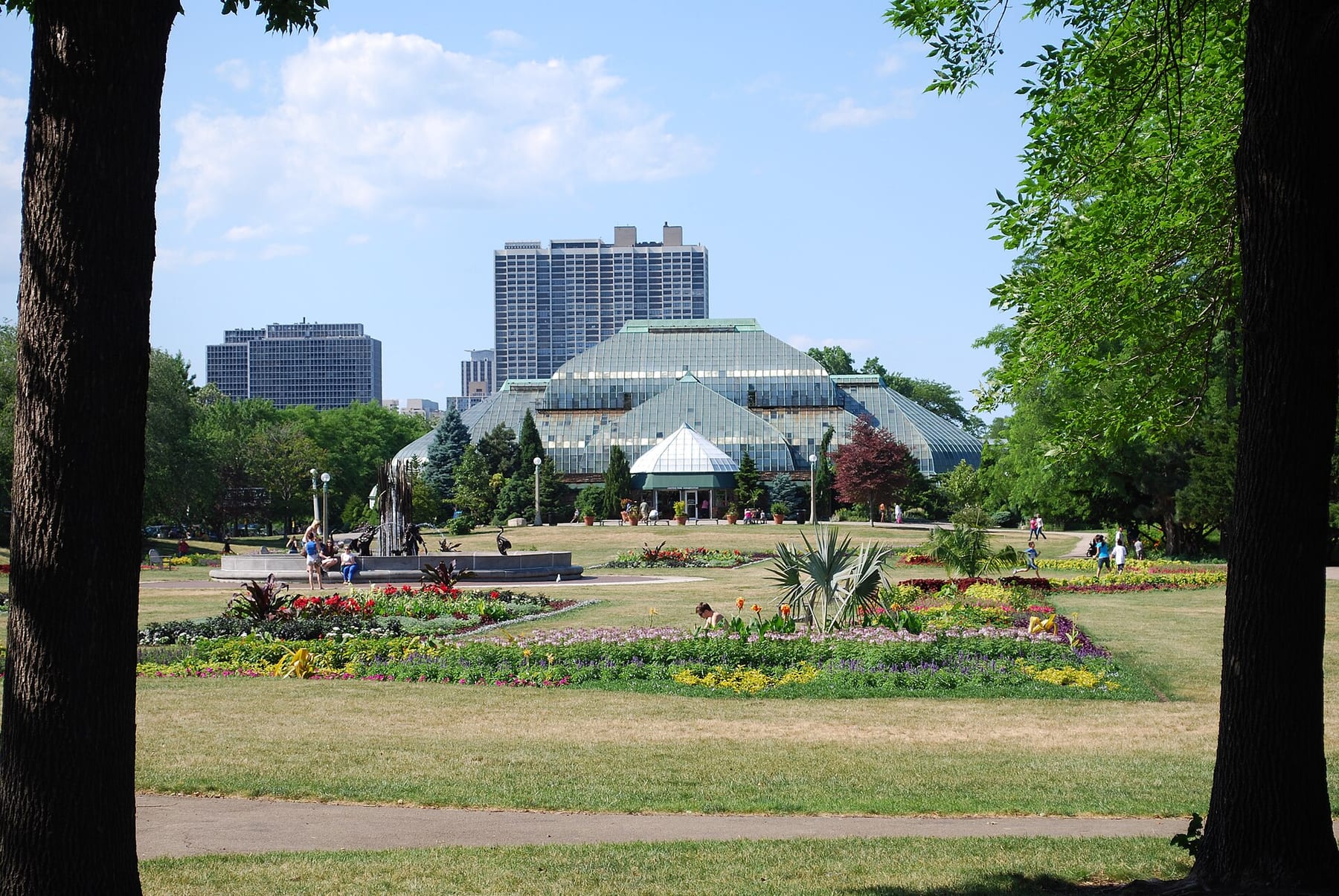The glass Lincoln Park Conservatory seen across its flower gardens on a summer afternoon