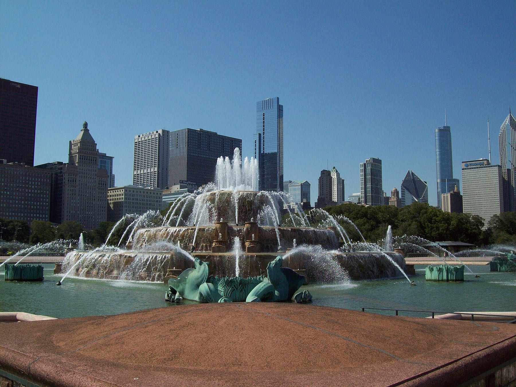 Buckingham Fountain in Grant Park on a clear day, with the Loop skyline rising behind its basins