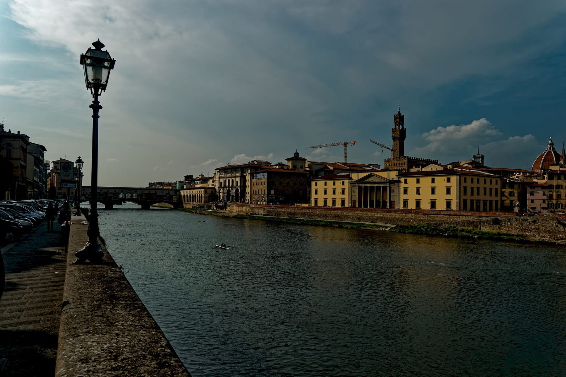 The Arno seen from the Lungarno on the south bank, with Ponte Vecchio at left and the Palazzo Vecchio tower and the cathedral dome across the water