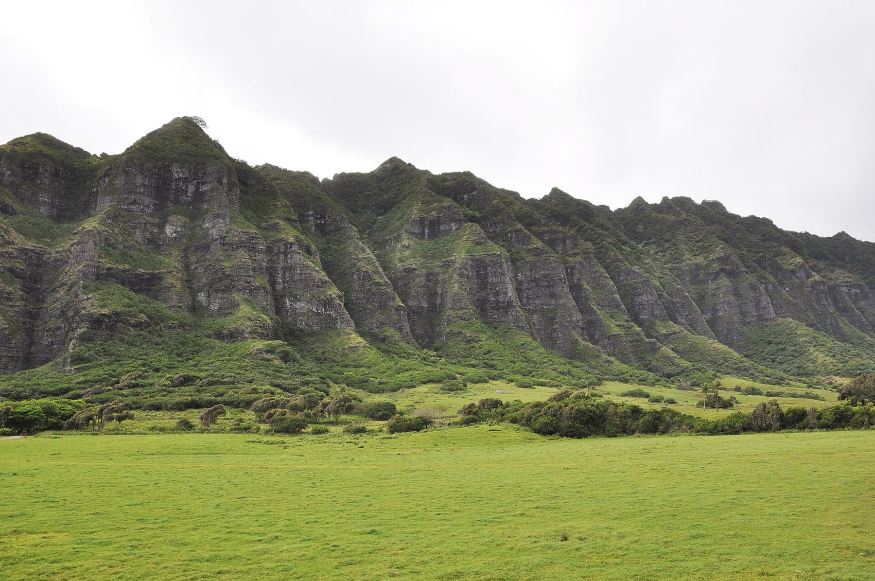 The green Koʻolau cliffs above the grass valley floor at Kualoa Ranch on Oahu’s windward coast