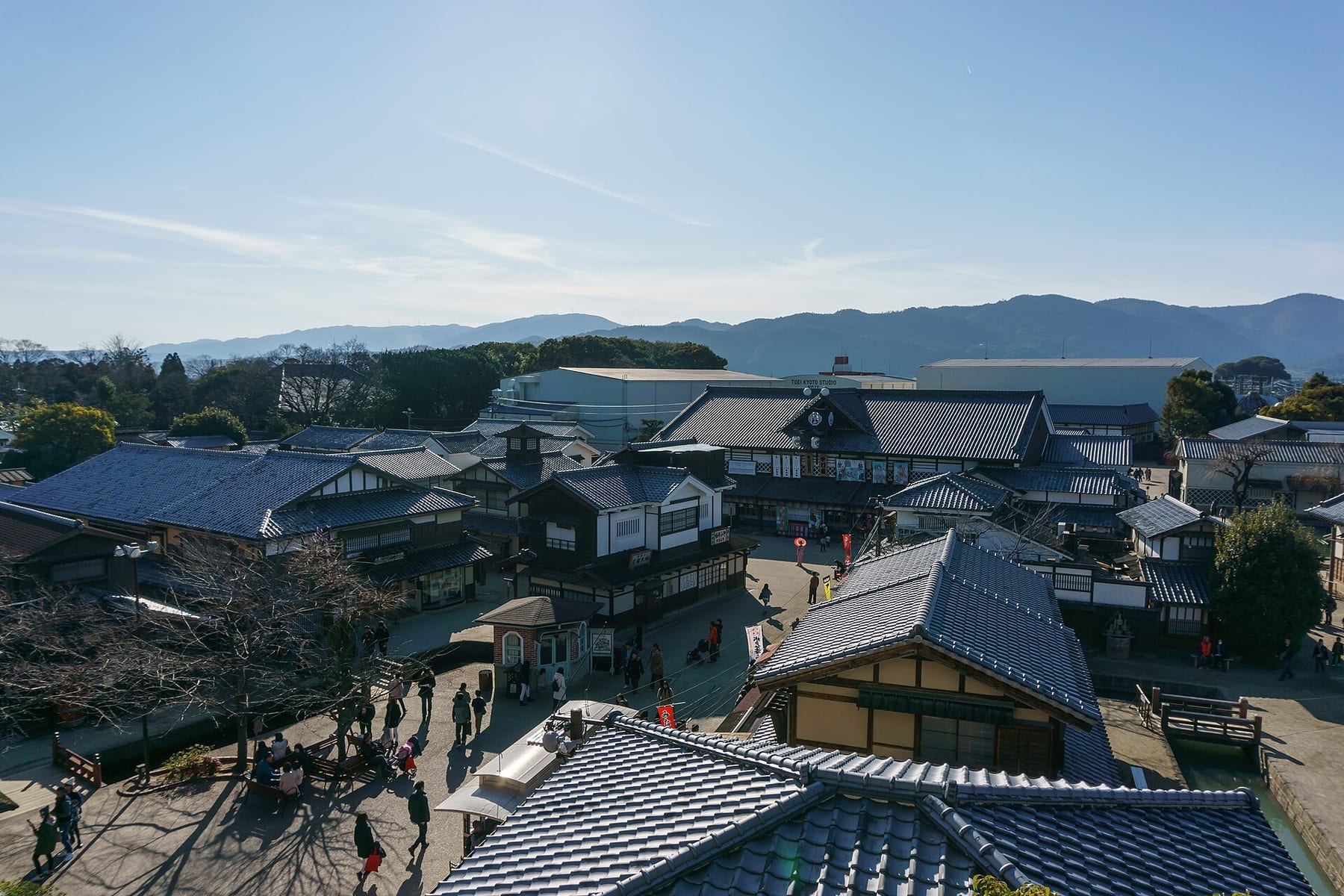 Tiled roofs and a busy street of the Edo-style film sets at Toei Kyoto Studio Park, now called Uzumasa Kyoto Village, seen from a stairway near the entrance