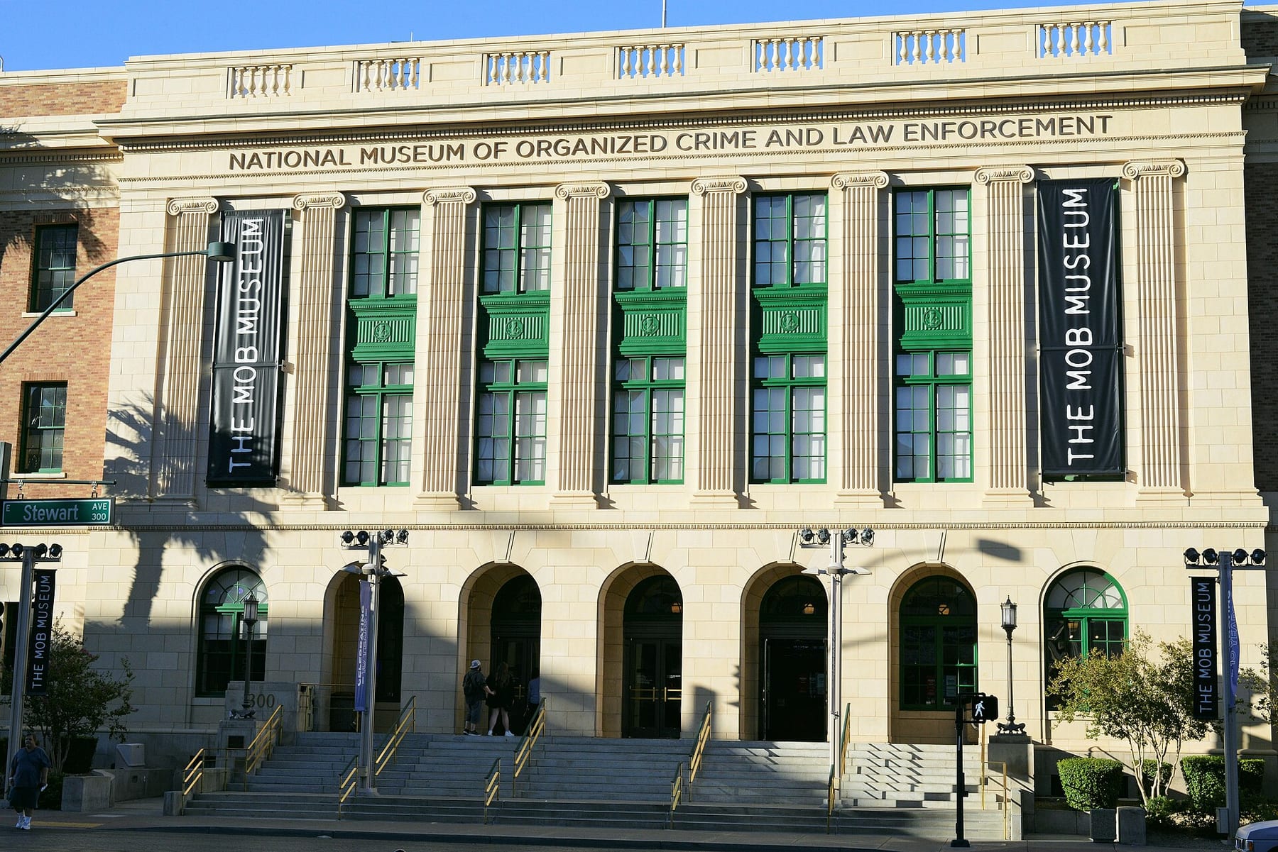 The columned facade of the Mob Museum, the former 1933 federal courthouse in Downtown Las Vegas, seen across the street with its banners and entrance steps, one of the three ticketed visits on this page