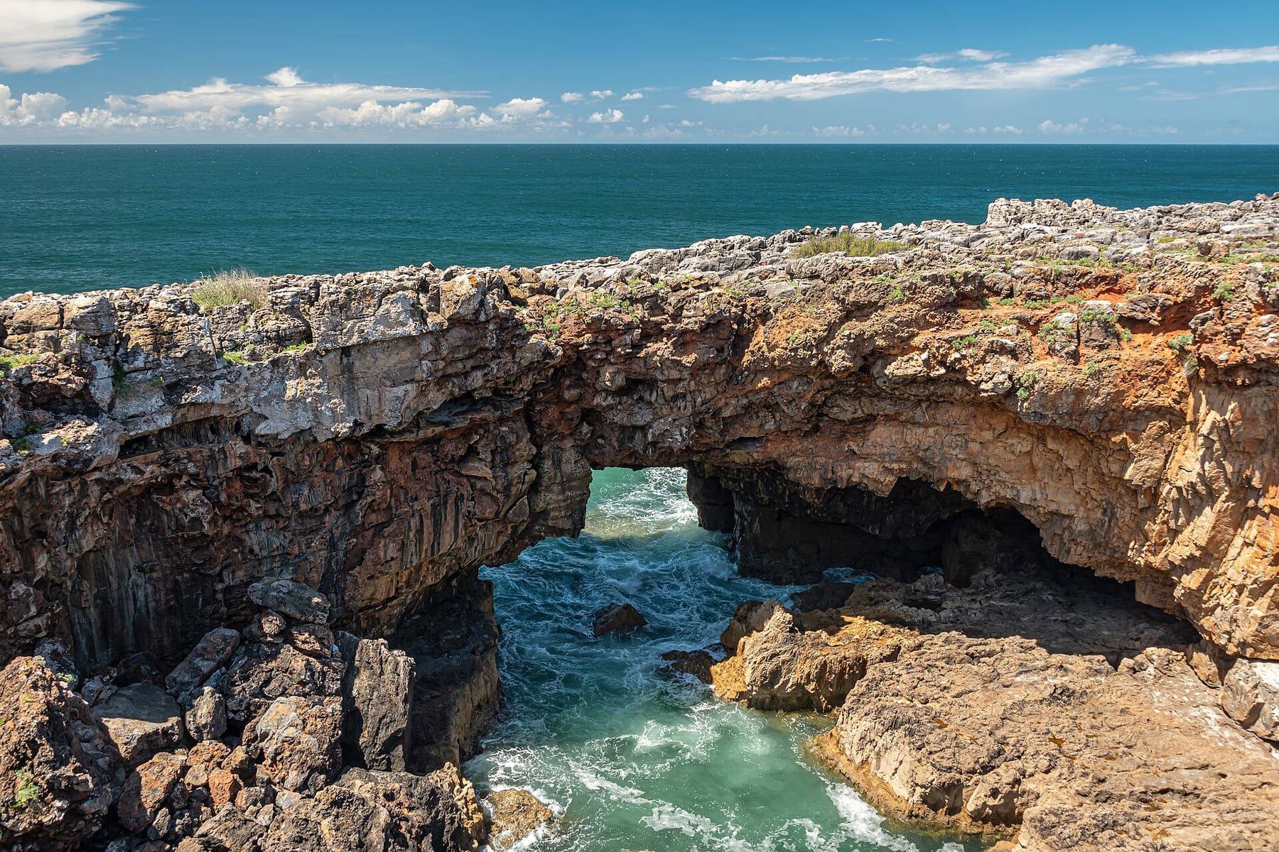 The Boca do Inferno sea arch on the rocky Cascais coast, with turquoise water flowing into the cave beneath the rock
