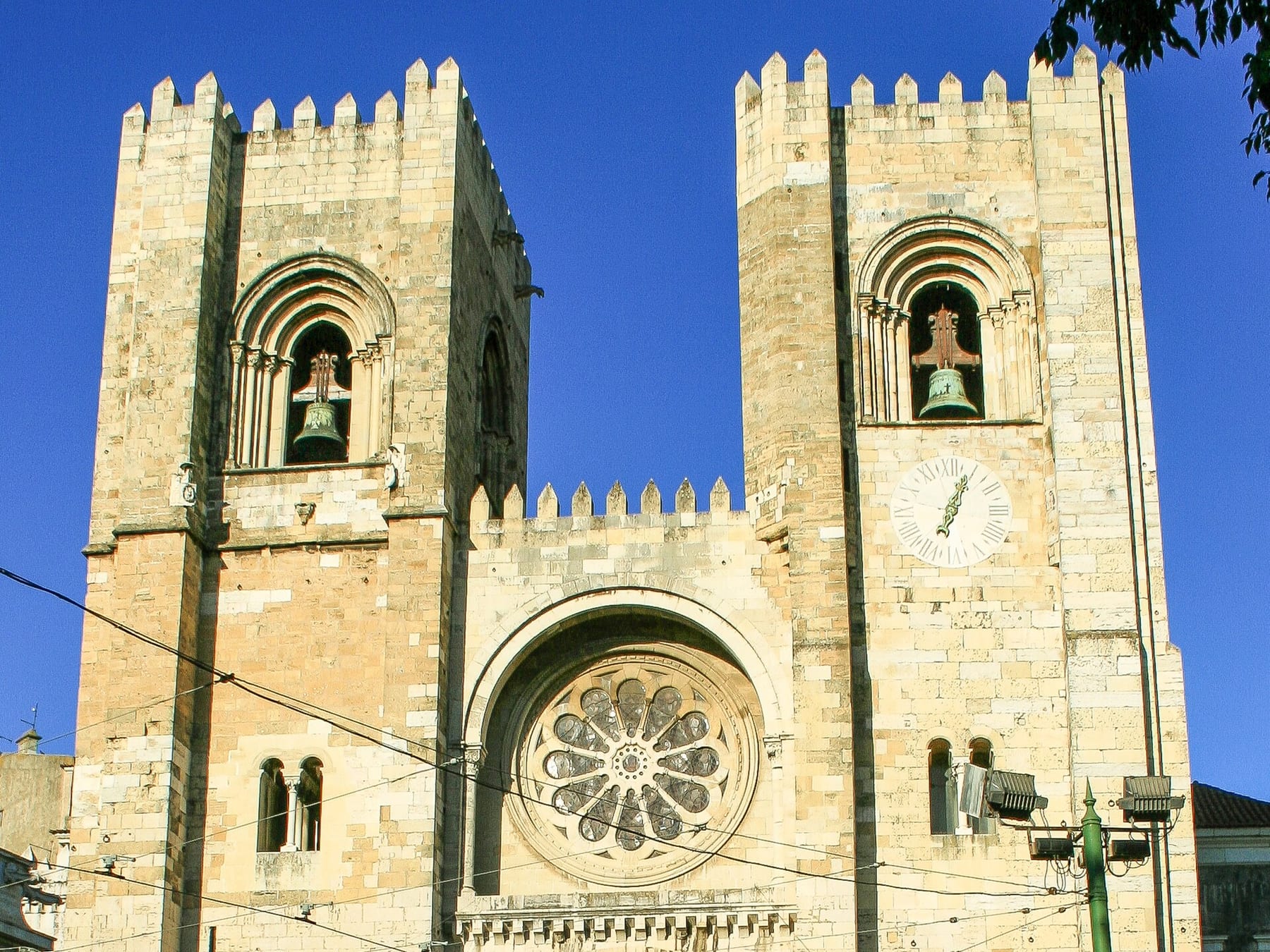 The two crenellated towers, clock and rose window on the west façade of the Sé, Lisbon Cathedral