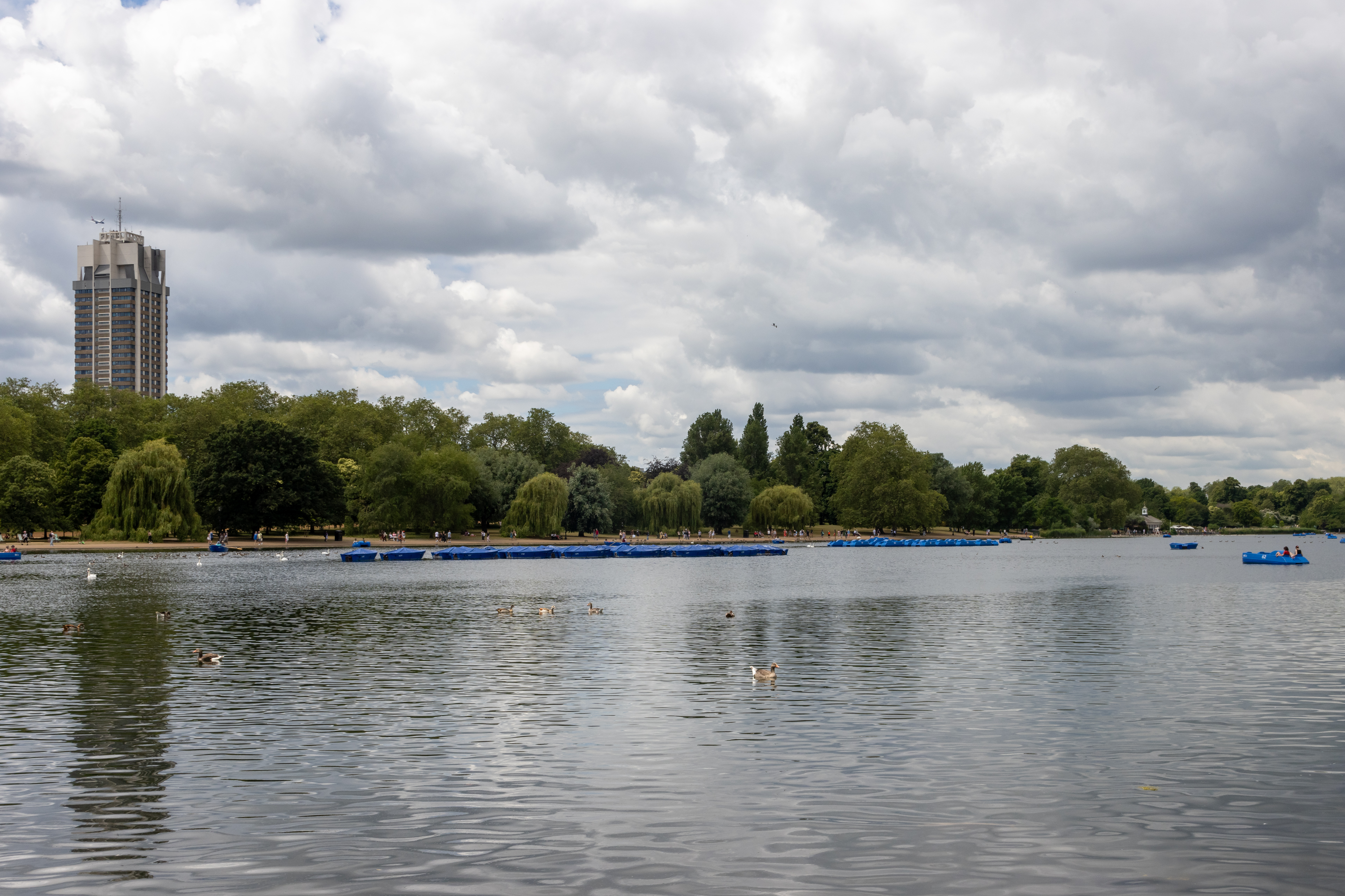 Visitors walking beside the Serpentine in Hyde Park, London, free to enter every day