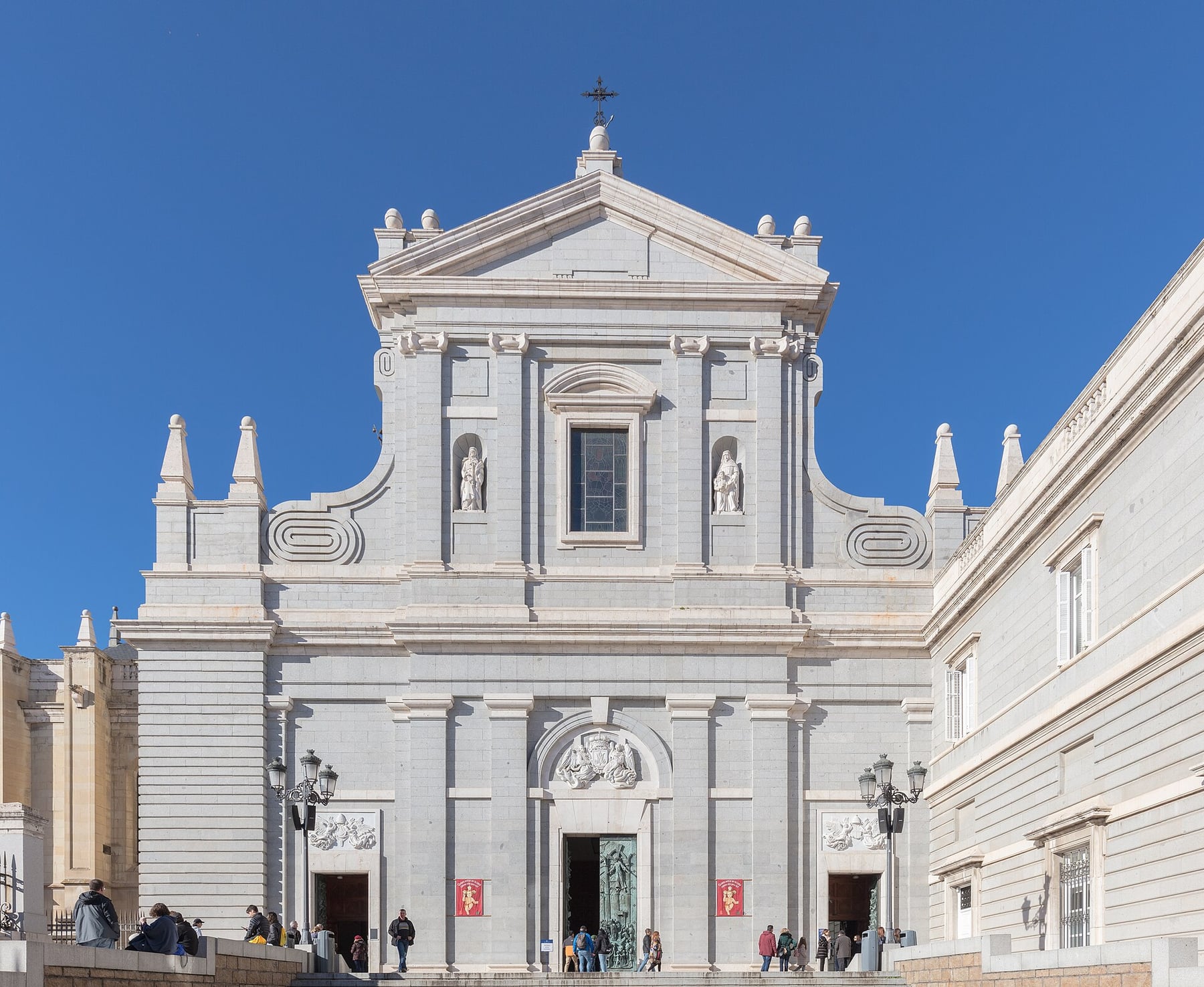 The stone main façade and entrance steps of Almudena Cathedral in Madrid, free to enter outside services